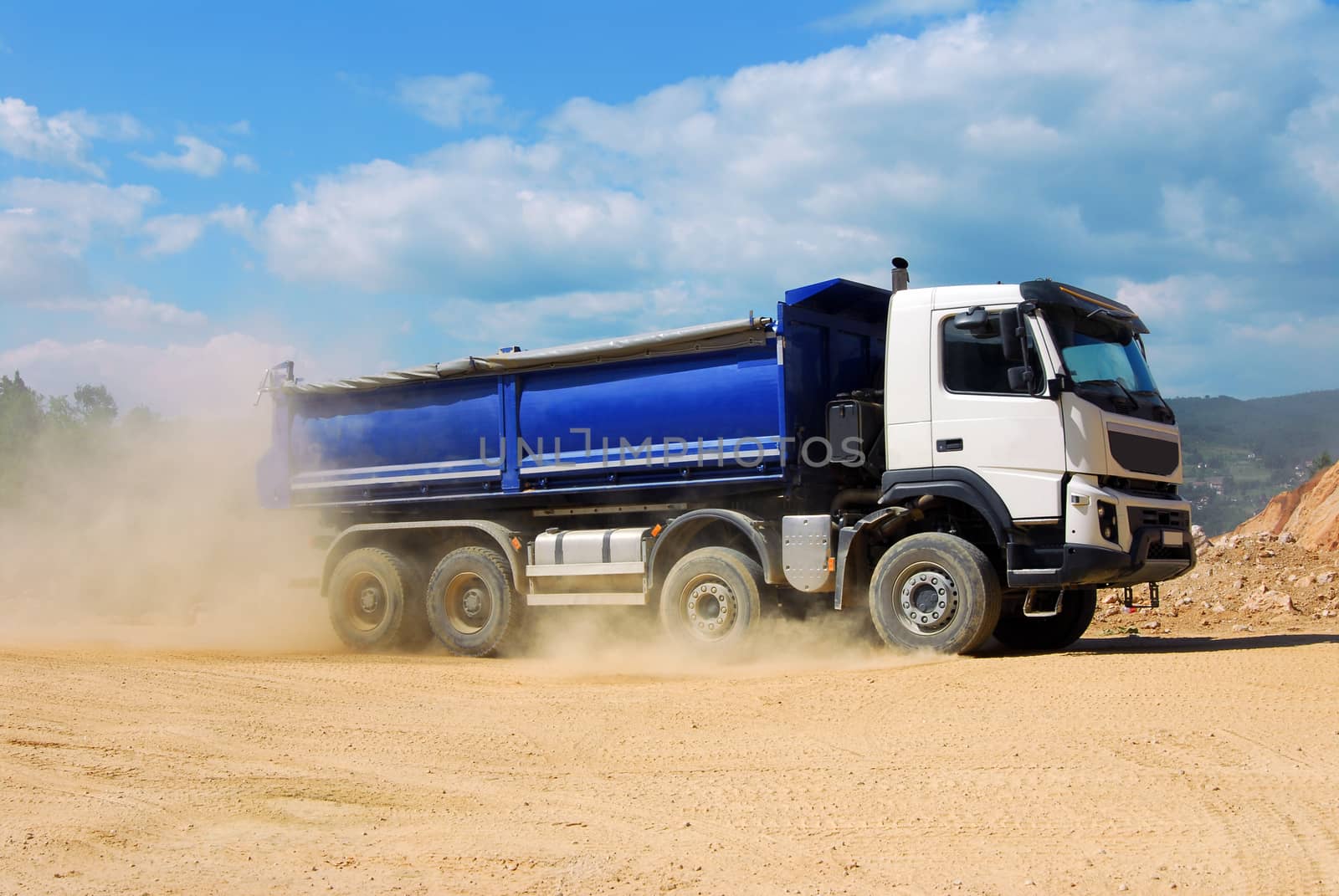large dump truck driving in the dust in the quarry