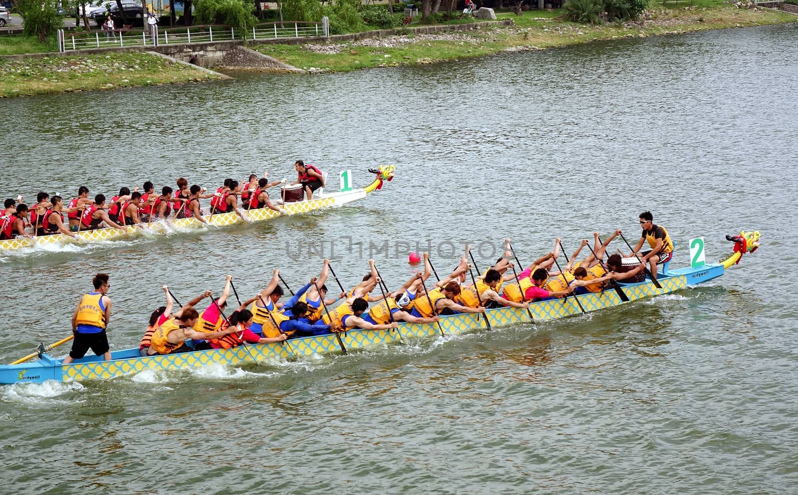 KAOHSIUNG, TAIWAN - MAY 25, 2014: Two unidentified teams compete in the 2014 Dragon Boat Races on the Lotus Lake.