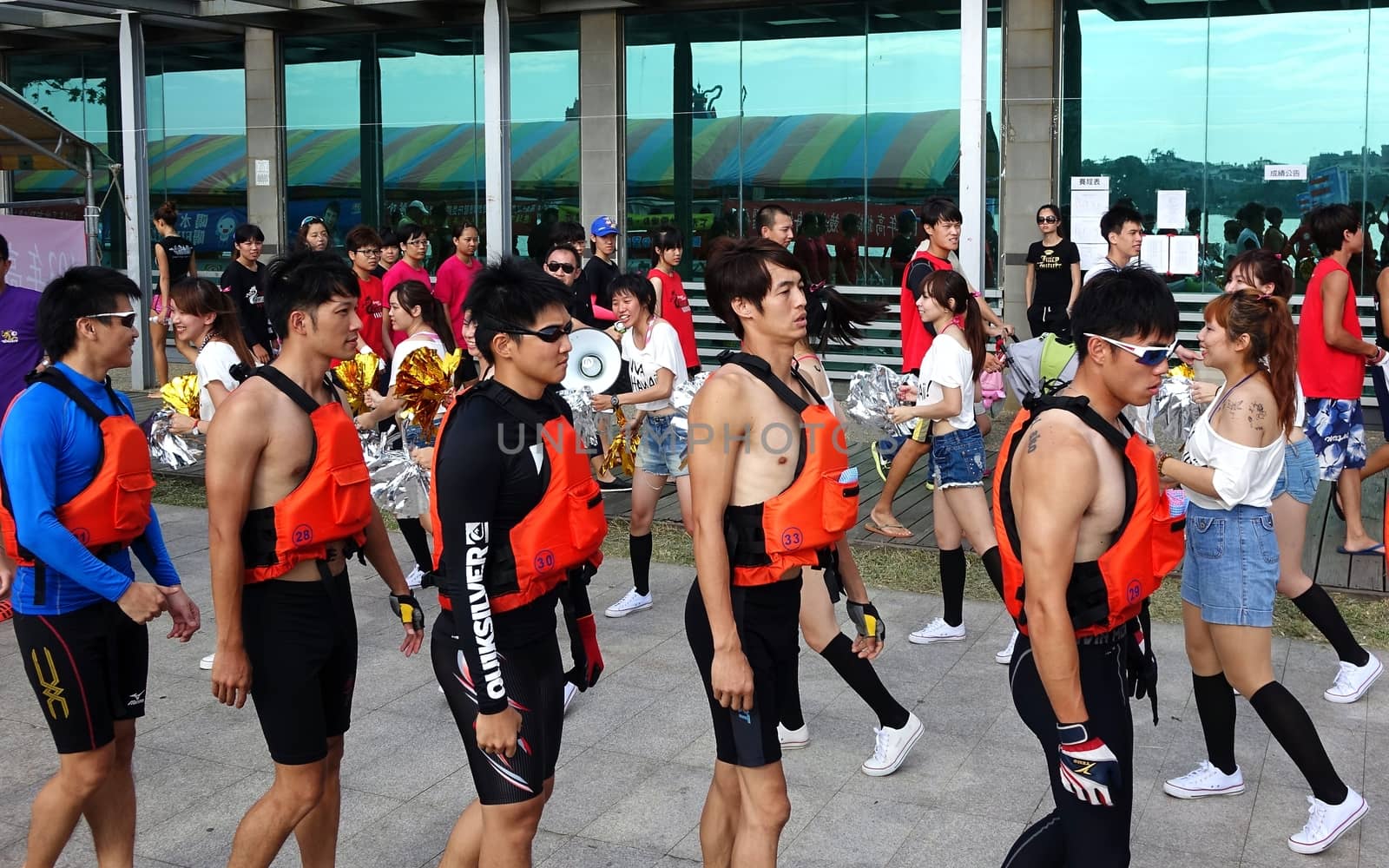 KAOHSIUNG, TAIWAN -- MAY 25, 2014: Pretty cheerleaders spur on a team of athletes as they get ready to take part in the 2014 Dragon Boat Races on the Lotus Lake.