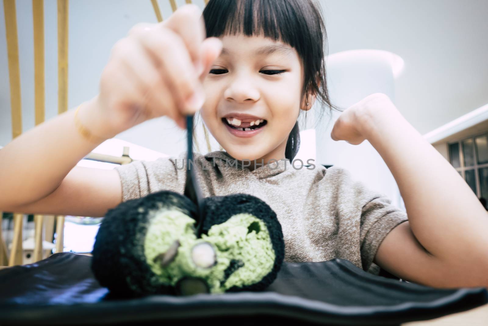 Little kid is happy eating green tea matcha cake roll