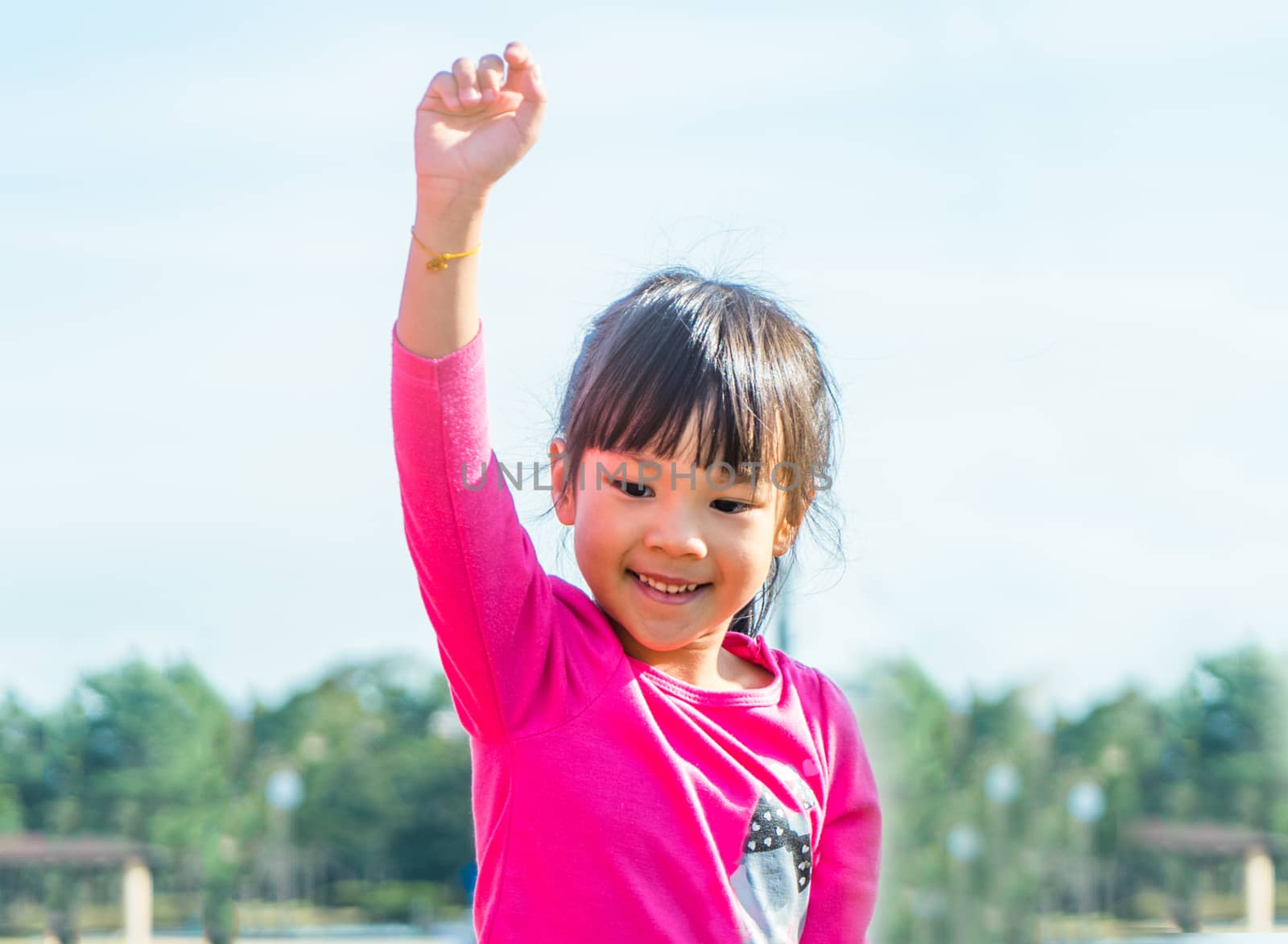 Happy Asian girl with her hand up.