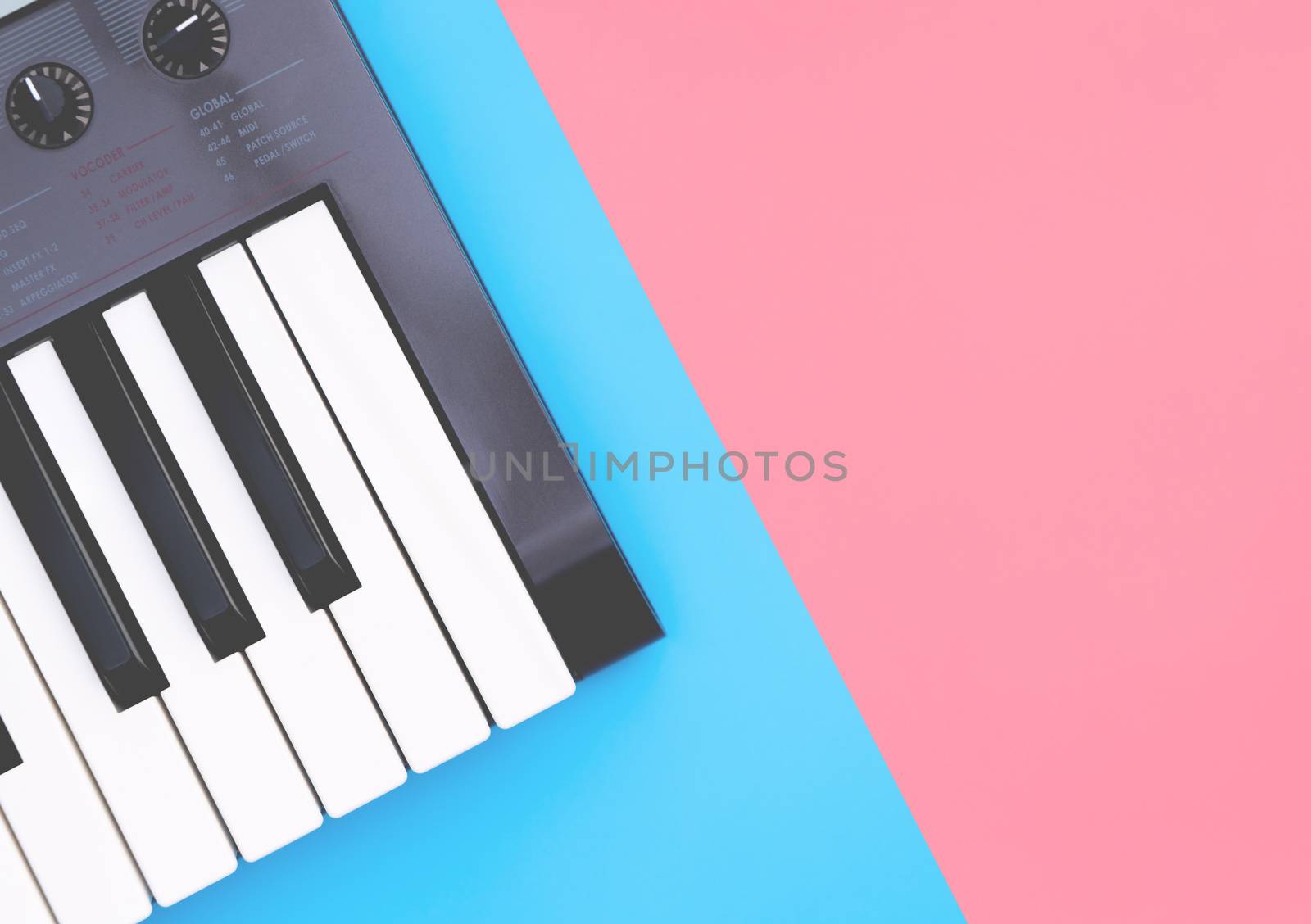 Music keyboard synthesizer instrument on blue pink copy space by junce