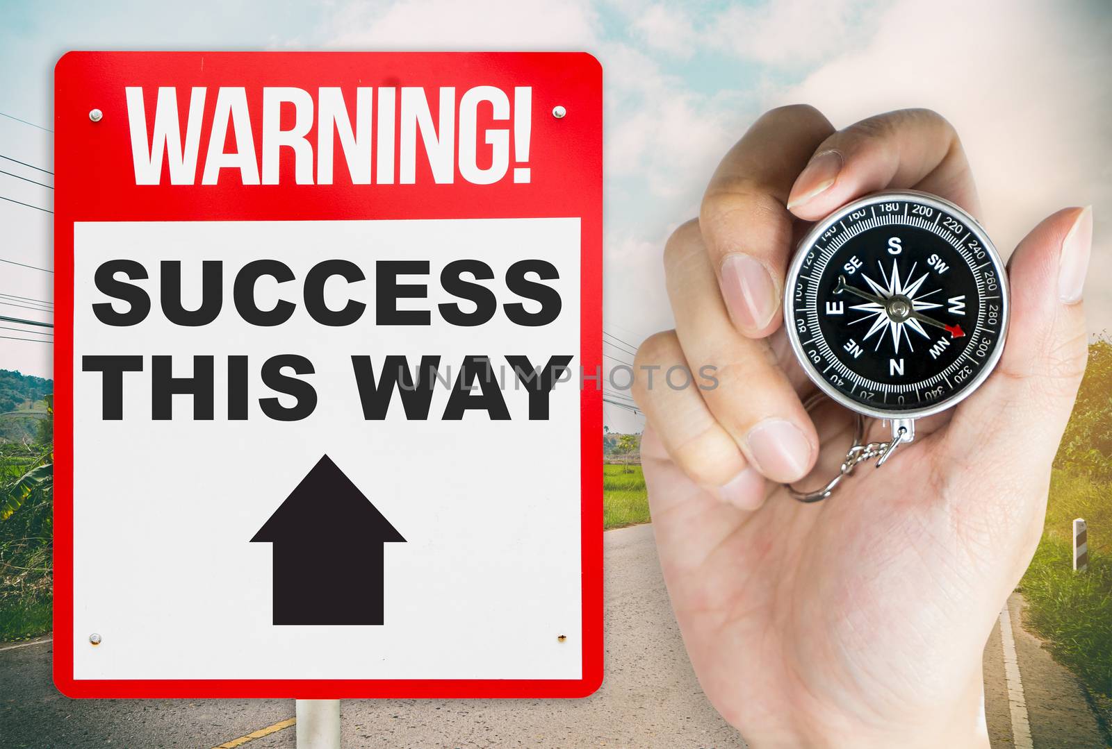 Holding compass for the way to success warning concept signage