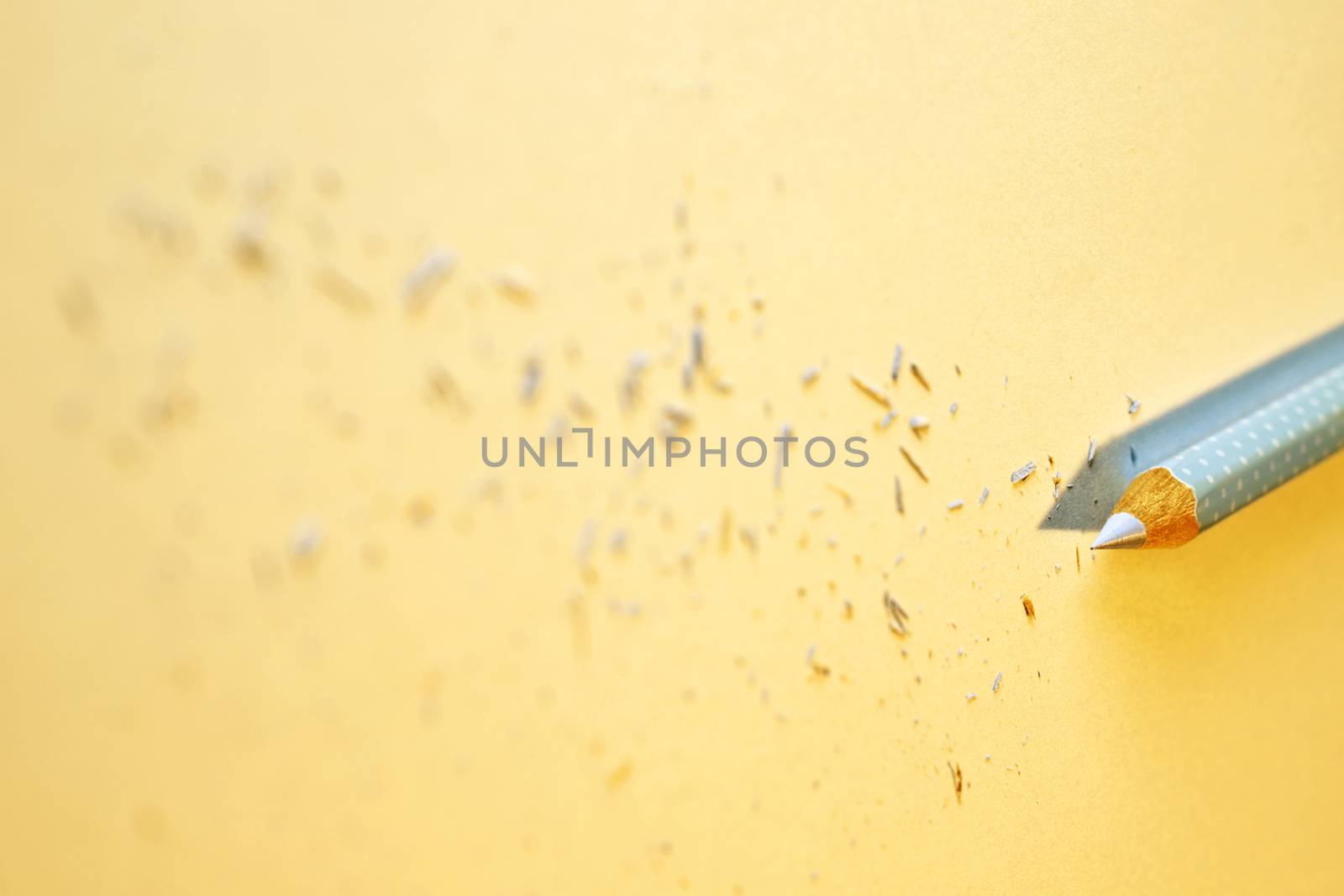  Sharpened wooden pencil on yellow background , beautiful pencil shavings all around 