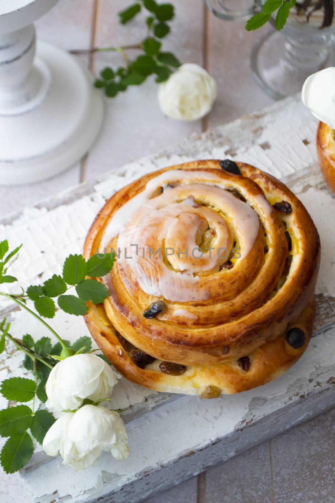 Cinnamon bun swirled with raisins, vintage and shabby style, vertical image