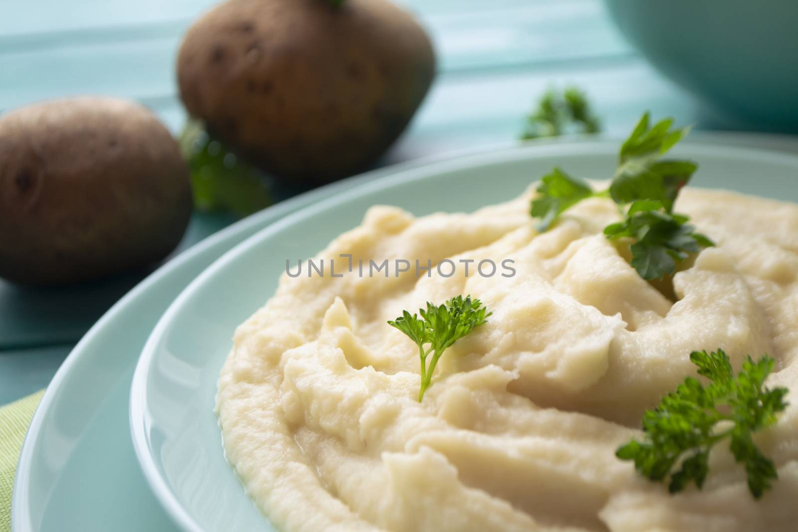 Rustic mashed potatoes with greens in bowl closeup