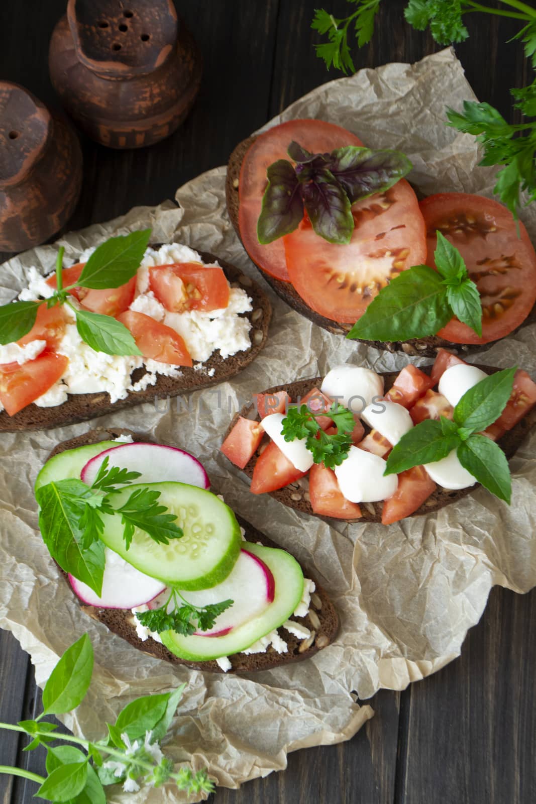 Italian bruschetta with tomatoes, parmesan, cucumber, basil, mozarella, garlic and olive oil. Mix bruschetta flat lay