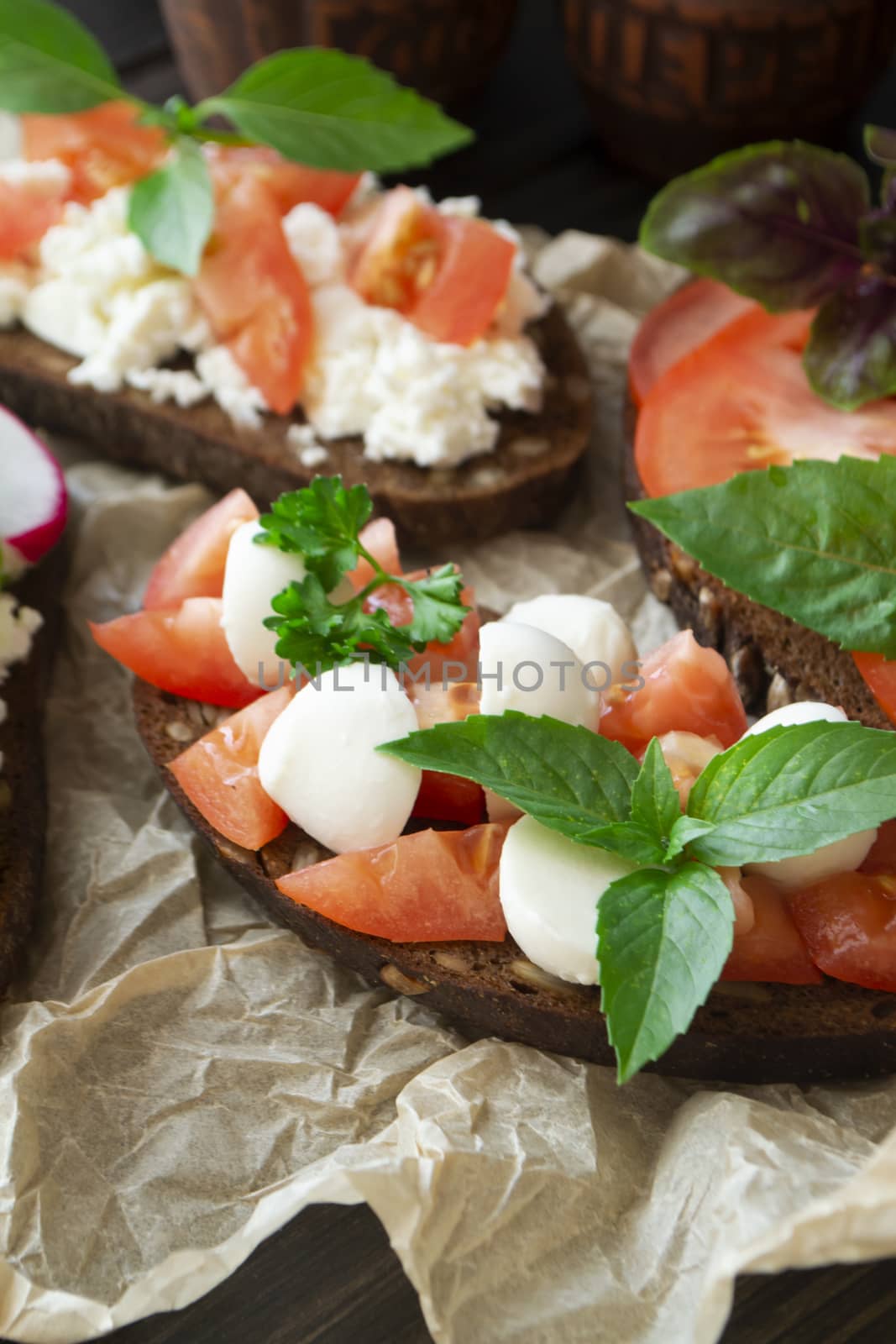 Variety of bruschetta sandwiches. Mix bruschetta with mozarella, tomato, basil. Vertical image