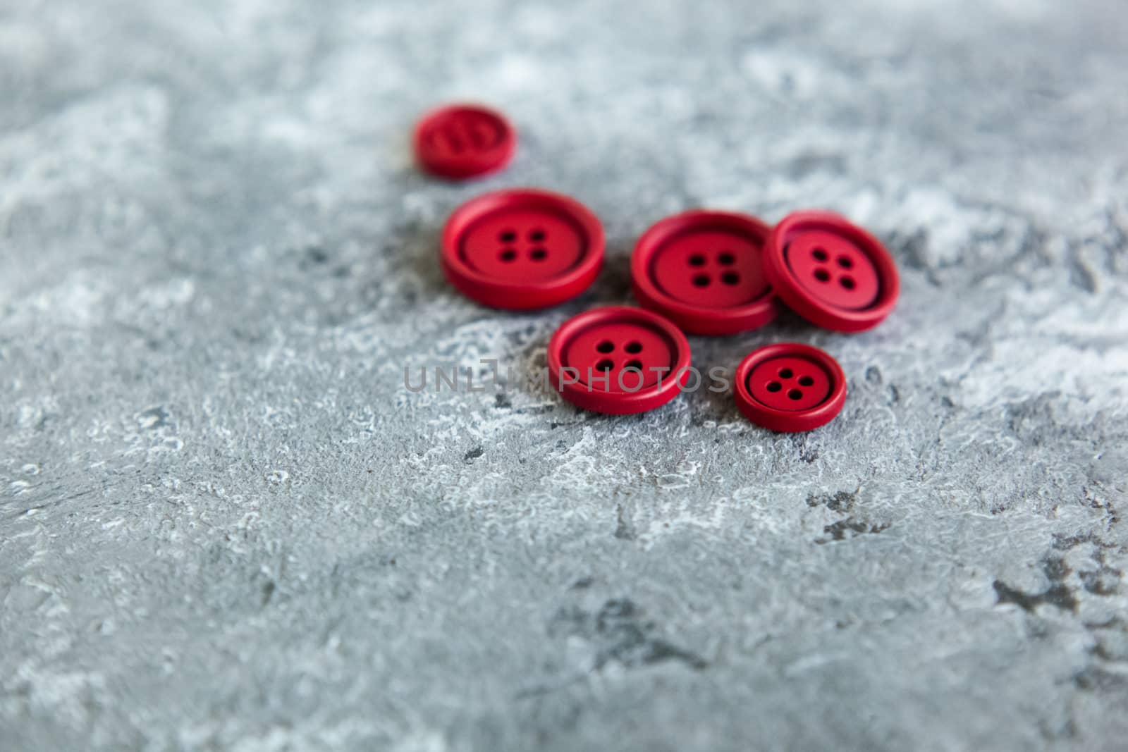 Pile matte buttons on concrete background, macro bokeh. beautiful needlework by polyats