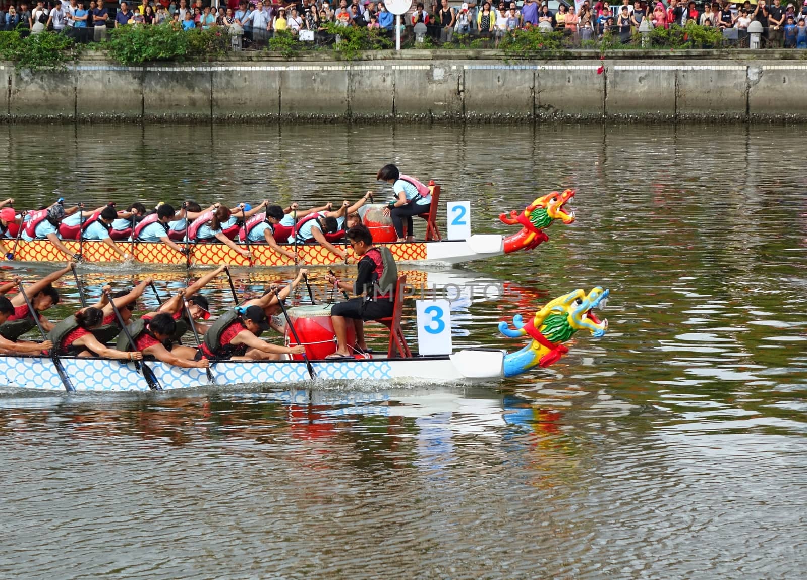 KAOHSIUNG, TAIWAN -- JUNE 9, 2016: Two unidentified teams compete in boat races on the Love River during Dragon Boat Festival.
