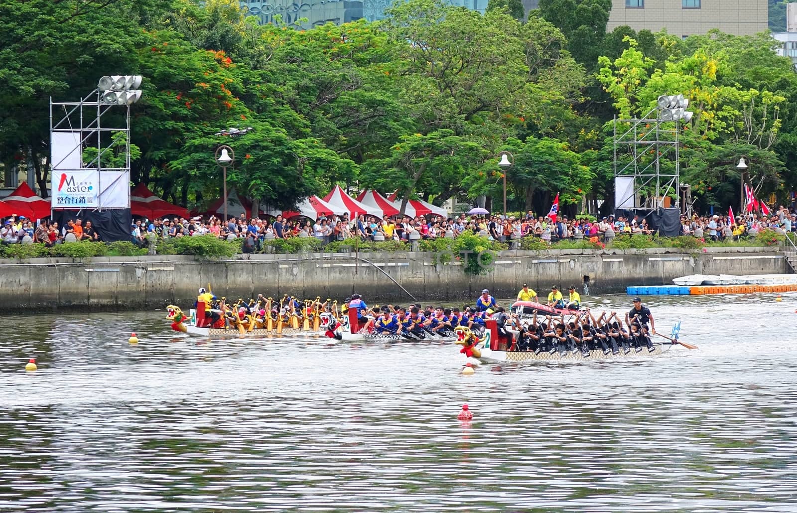KAOHSIUNG, TAIWAN -- JUNE 9, 2016: Three unidentified teams compete in boat races on the Love River during Dragon Boat Festival.
