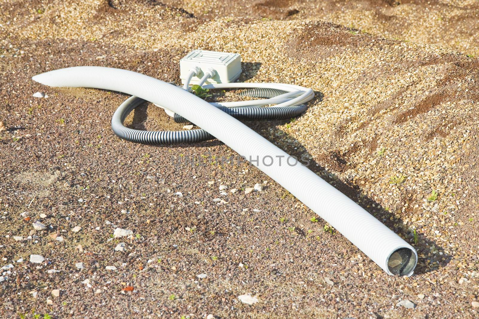 Flexible plastic pipe with electric cable coming out from the ground