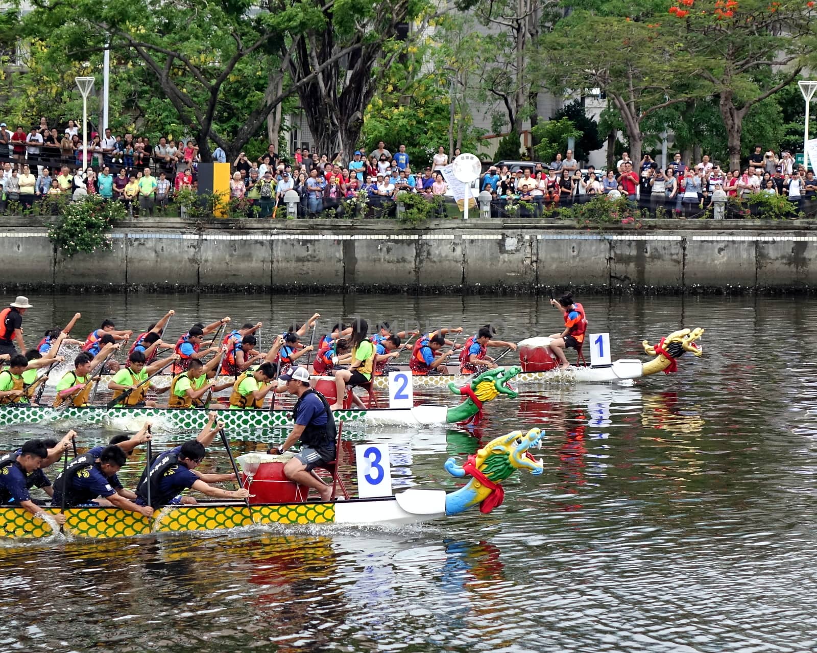 KAOHSIUNG, TAIWAN -- MAY 30, 2017: Three unidentified teams compete in the Dragon Boat Races on the Love River in Taiwan.