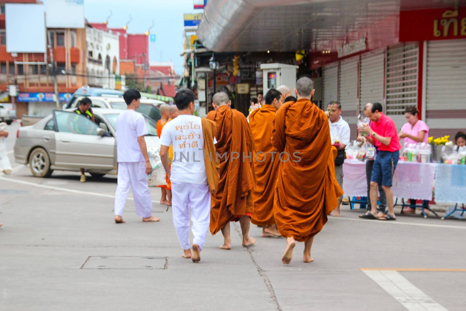The monk walked alms in the morning. by suthipong