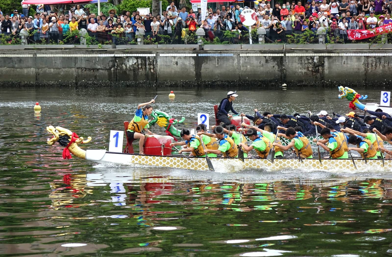 KAOHSIUNG, TAIWAN -- MAY 30, 2017: Three unidentified teams compete in the Dragon Boat Races on the Love River in Taiwan.