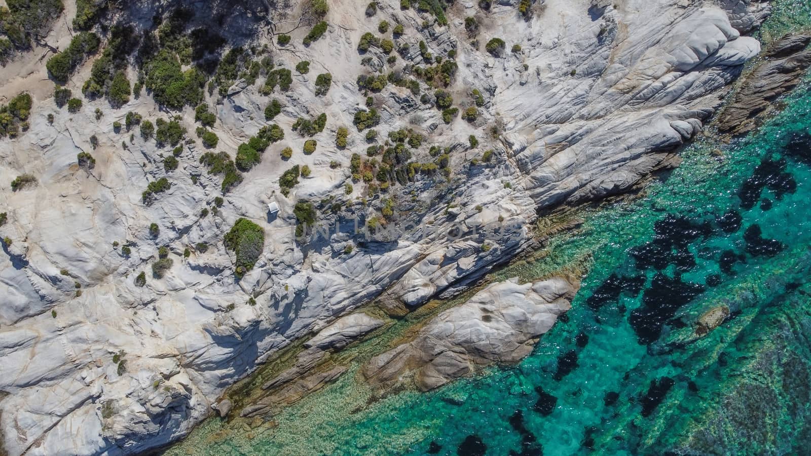Sithonia Chalkidiki peninsula aerial top view pan with rocky coastal and crystal-clear waters.
