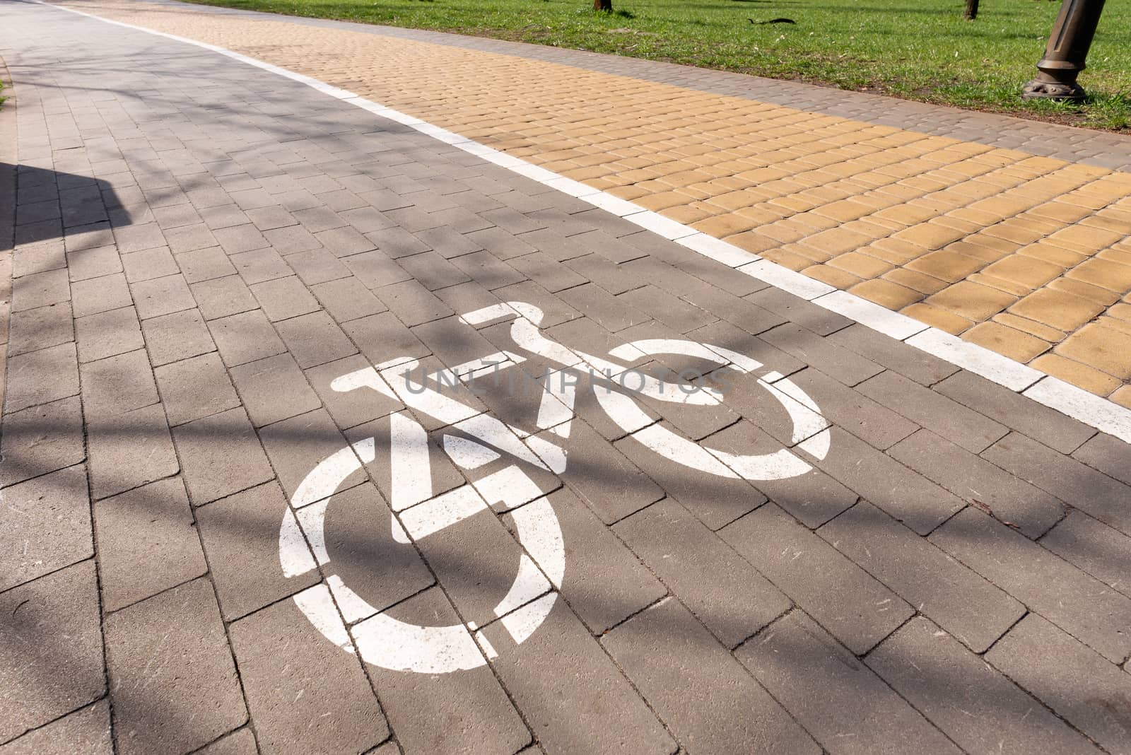 White bike path sign painted on a lane in the Natalka park of Kiev, Ukraine