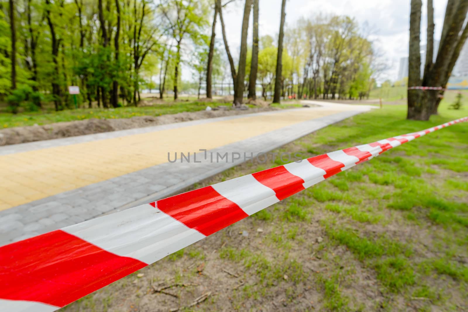 Red and white striped tape defining the border of a dangerous zone of construction work in process