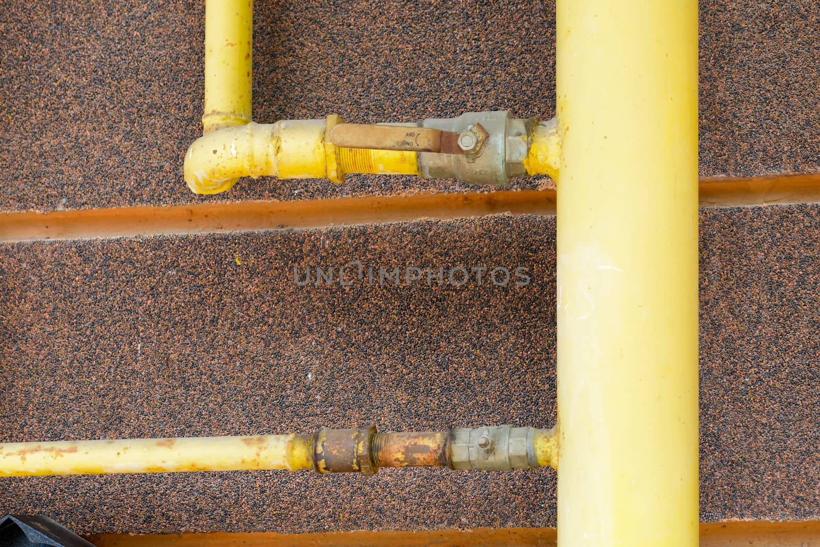 A yellow gas tube, with a tap, outside of a house to canalize the soft energy at home.