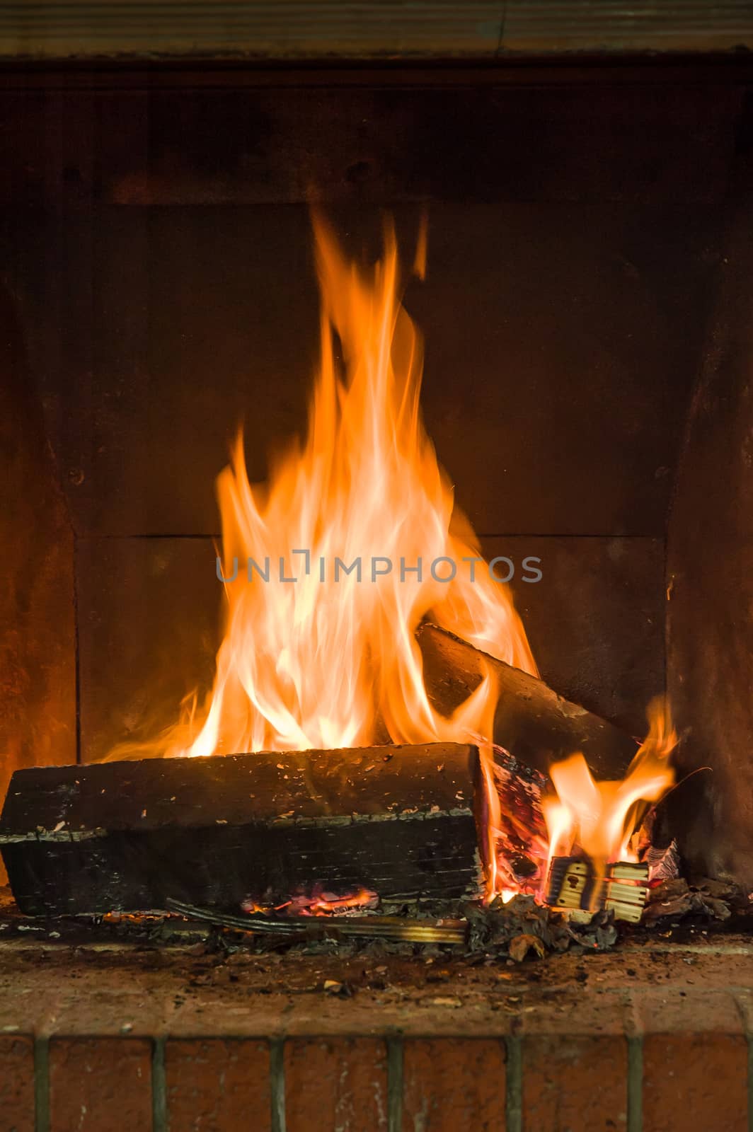 Warm flames burning some wood in a rustic fireplace