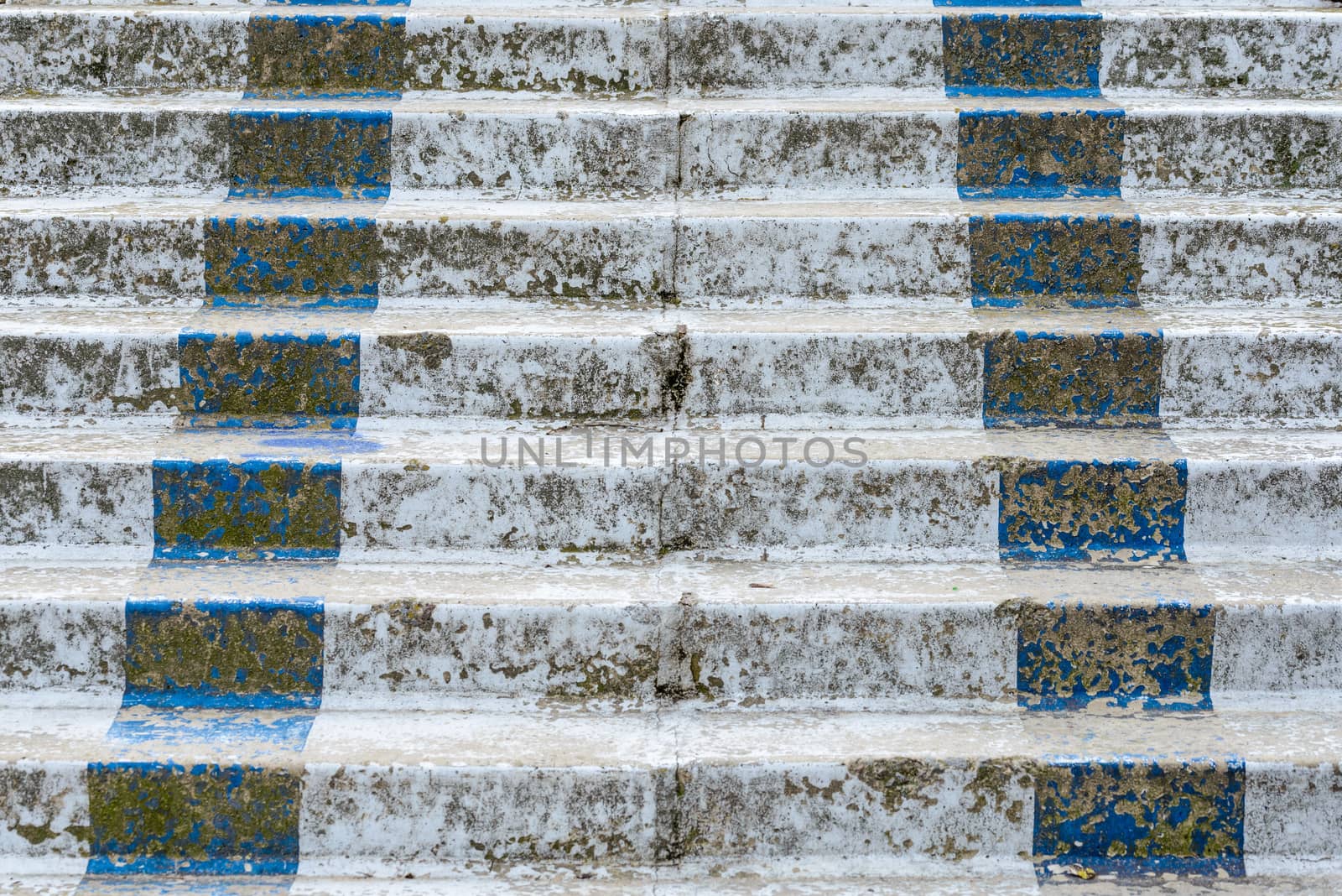 Detail of an old and broken white and blue concrete stairway