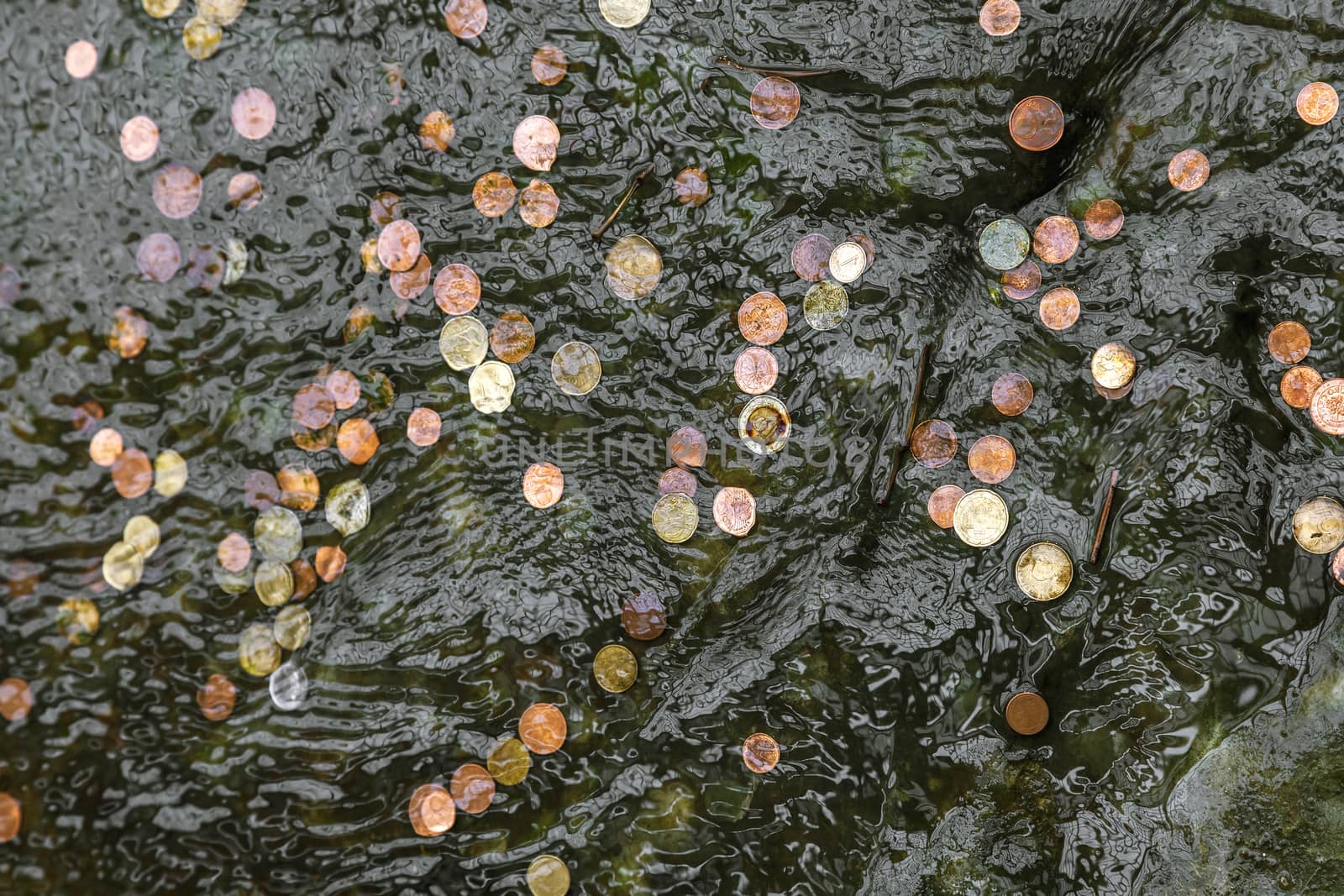 Coins in fountain water thrown by tourists by Goodday