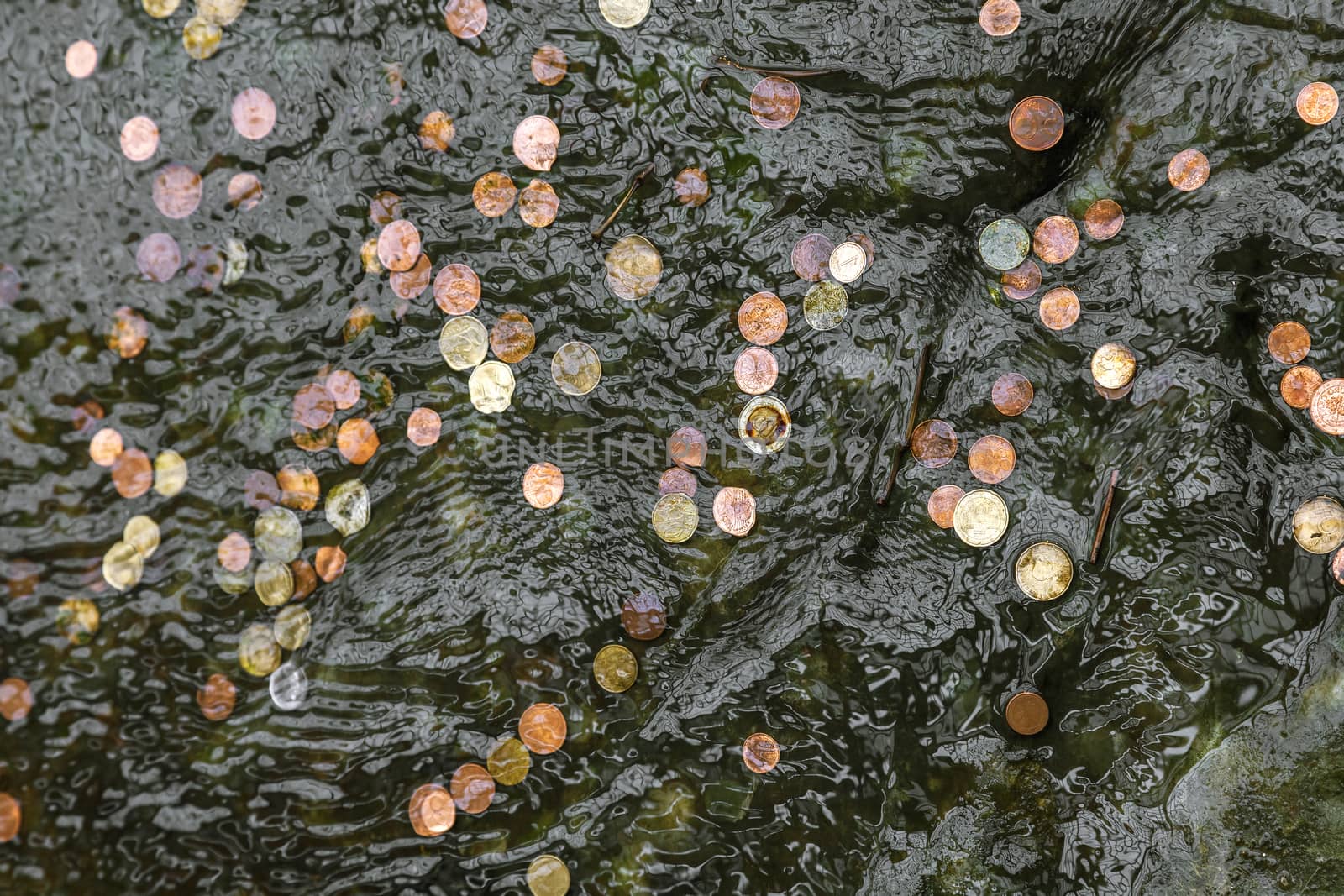 Coins thrown in fountain water in hope to return