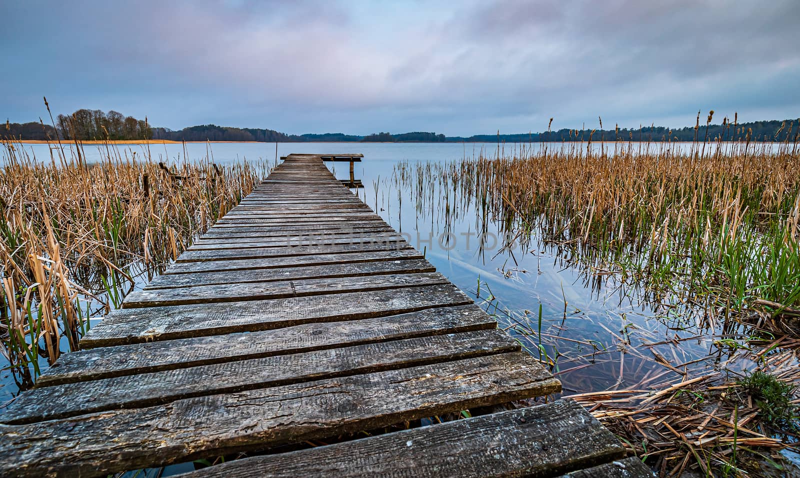 wooden pier on a lake in Mazury Region, Poland during early morning sunrise