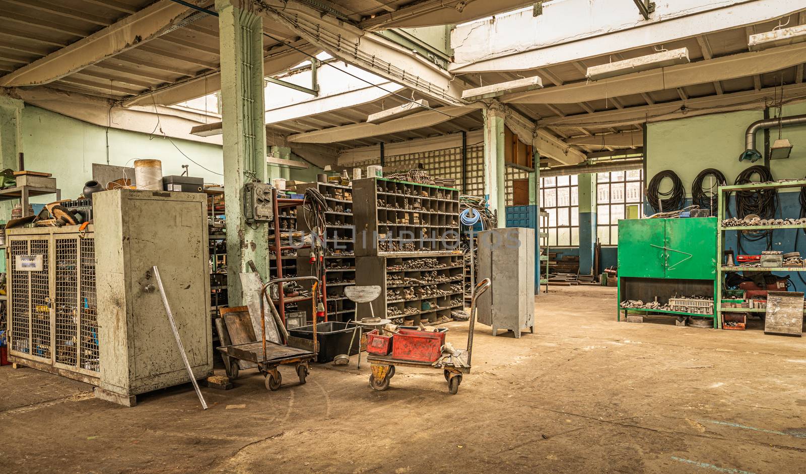 interior of old ironworks factory with shelves and trolley by mkenwoo