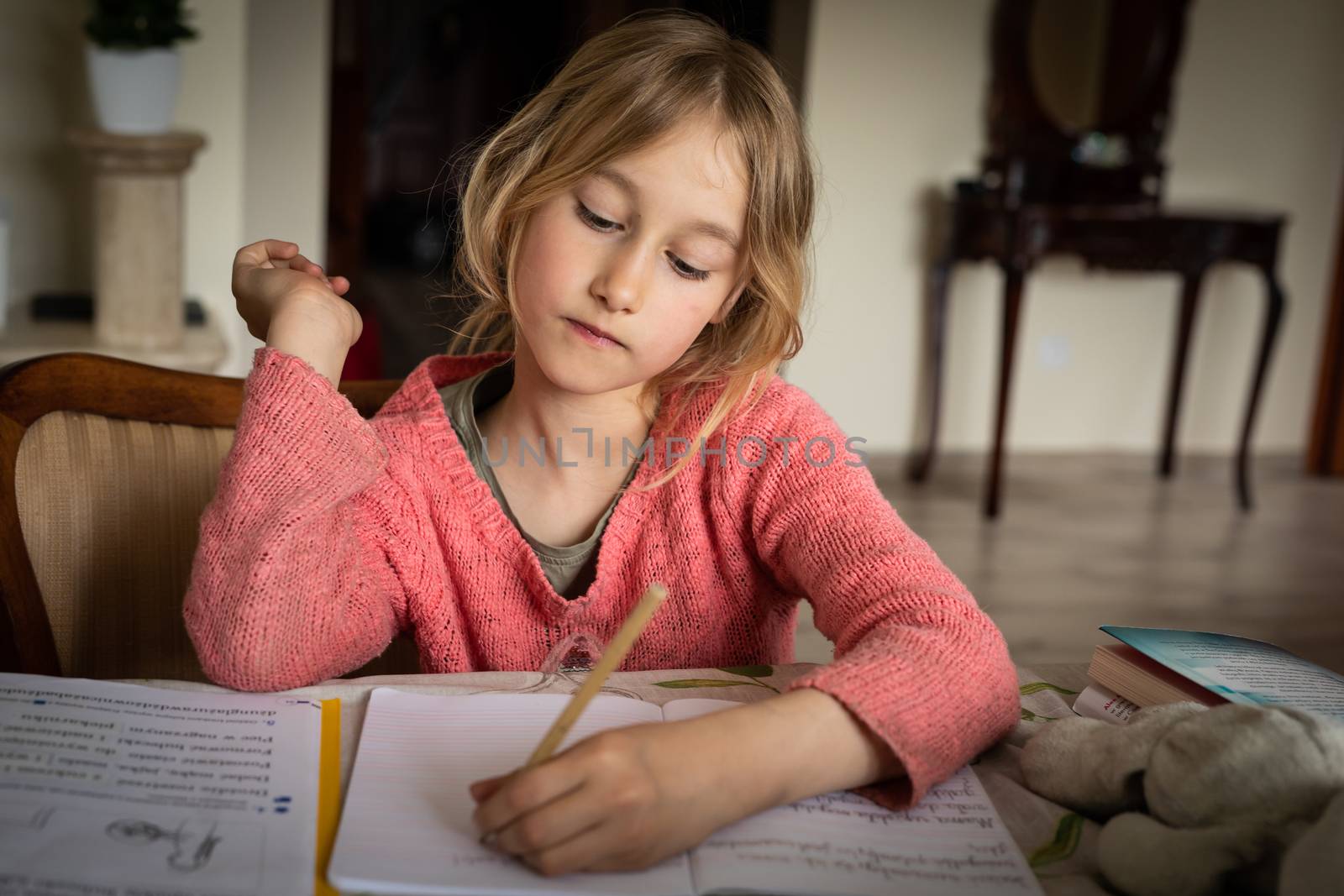 blond lefthanded girl writting homeworks during corona virus loc by mkenwoo