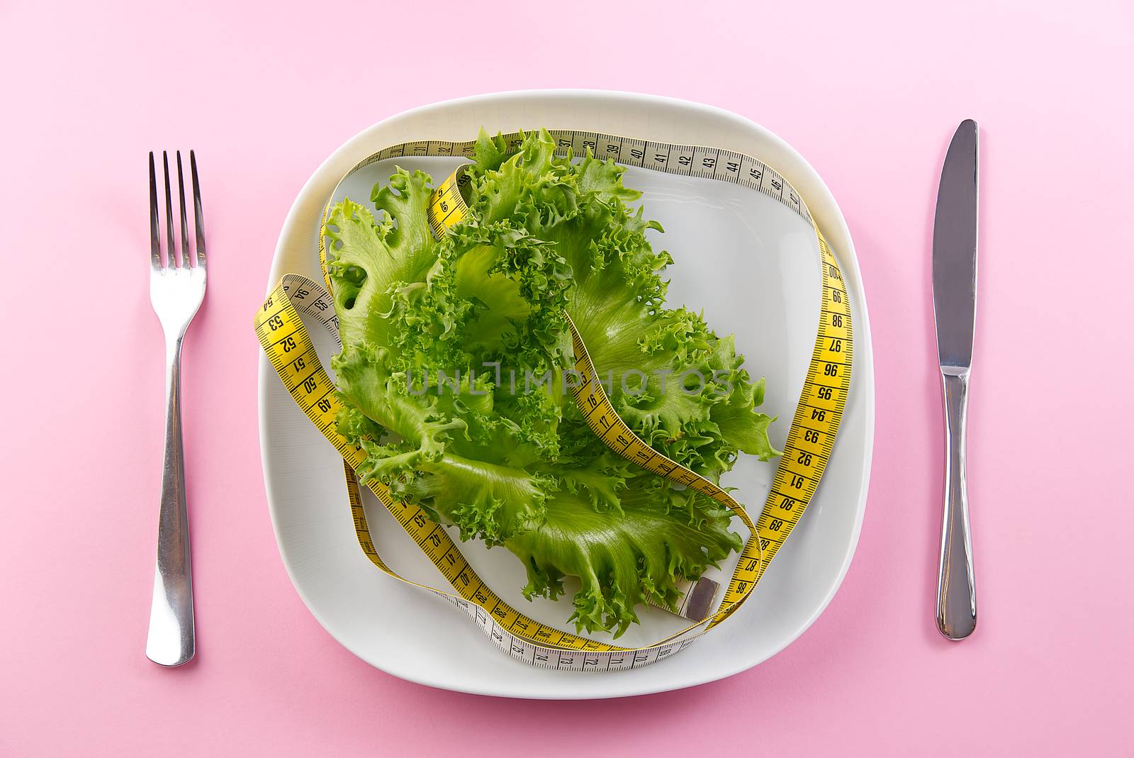 Bunch of vegetables isolated on pink background. salad tape weight. Pile of fresh vegetables salad leafe with measuring tape