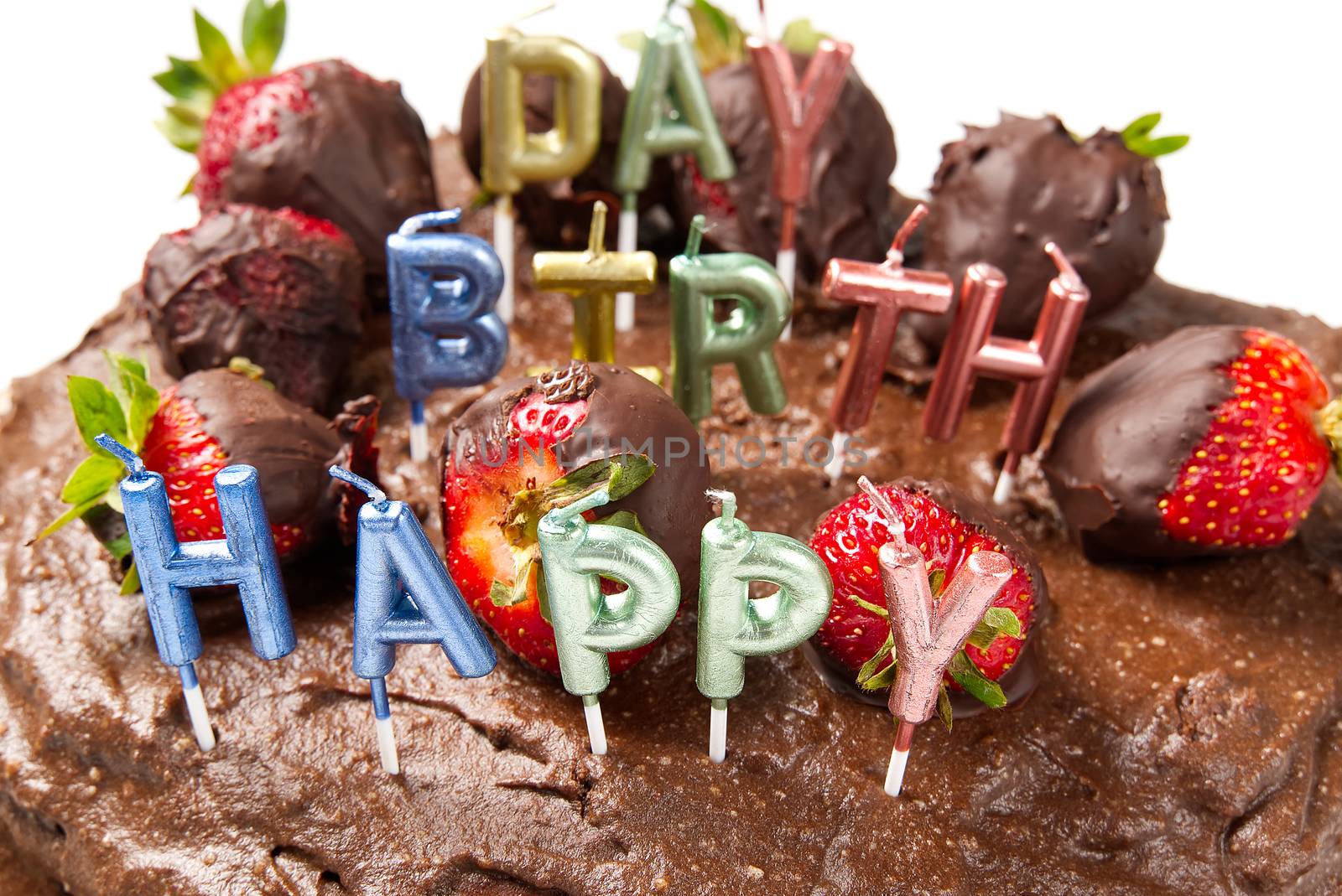 homemade chocolate cake with strawberries and happy birthday candles, close-up. by PhotoTime