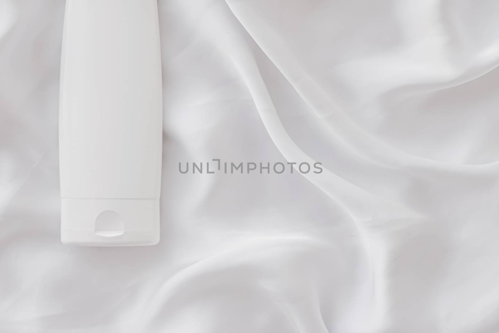 Blank label cosmetic container bottle as product mockup on white silk background, hygiene and healthcare