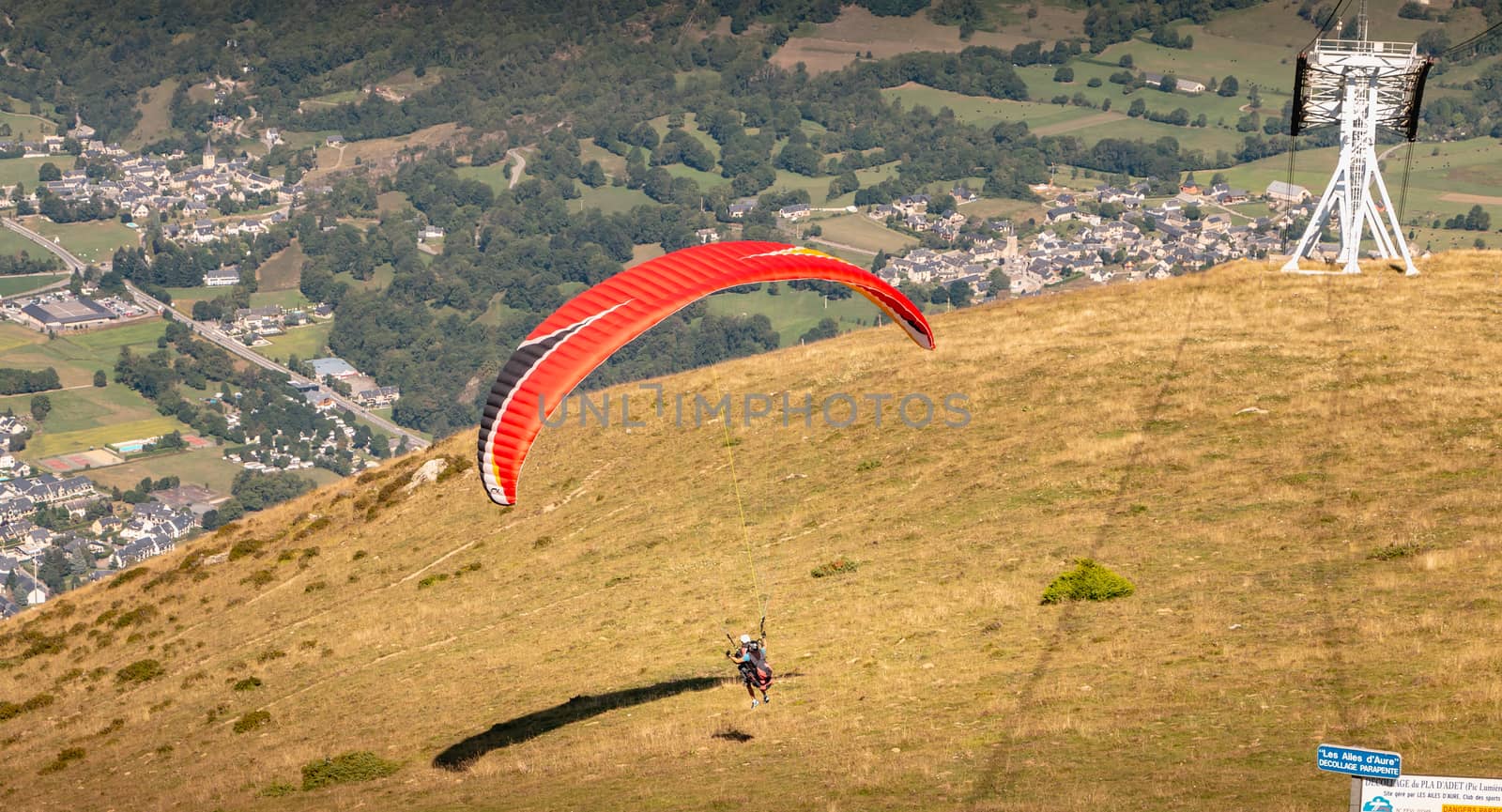 Saint Lary Soulan, France - August 20, 2018: takeoff of a paraglider from the top of the mountain, at 1700 meters altitude to fly over the valley on a summer day