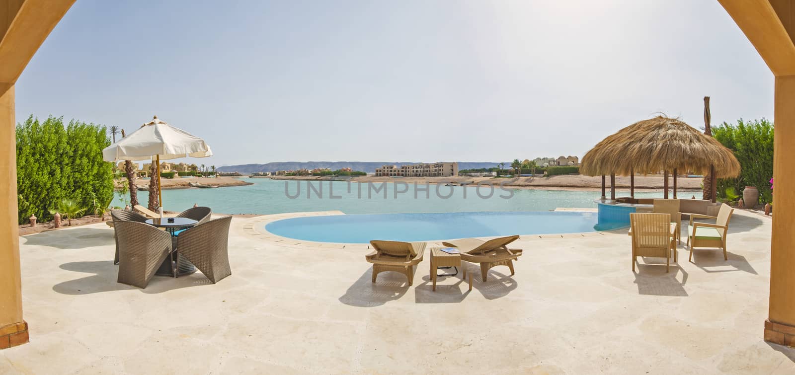 Luxury villa show home in tropical summer holiday resort with infinity swimming pool and sea view