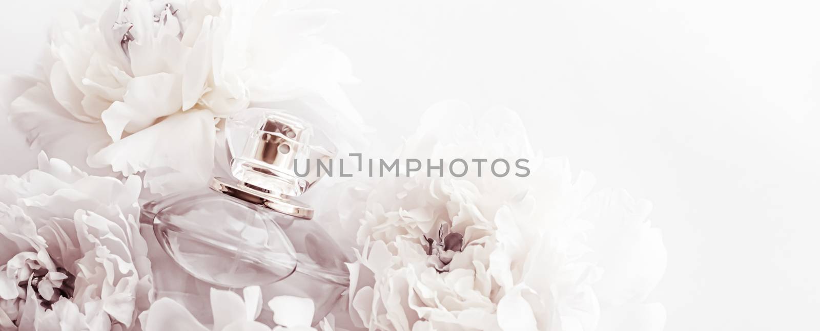 Chic fragrance bottle as luxe perfume product on background of peony flowers, parfum ad and beauty branding design