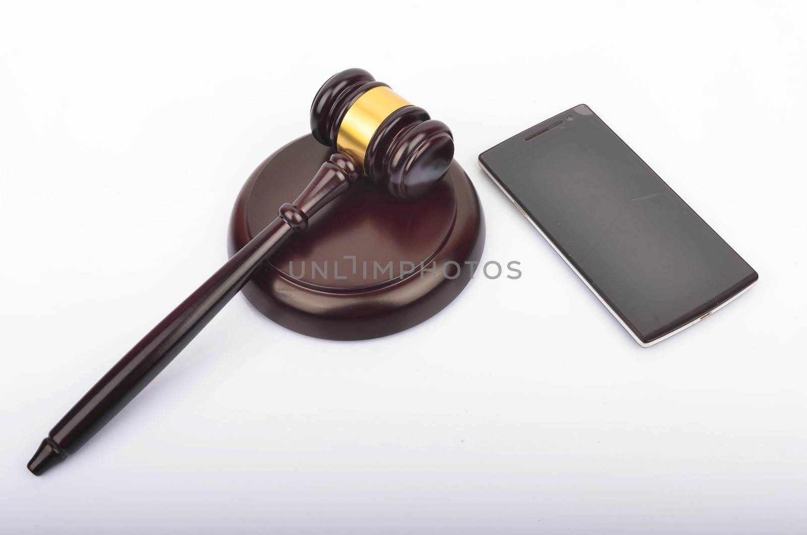 Judge hammer or gavel with smartphone on white background. Justice and law concept. Selective focus.
