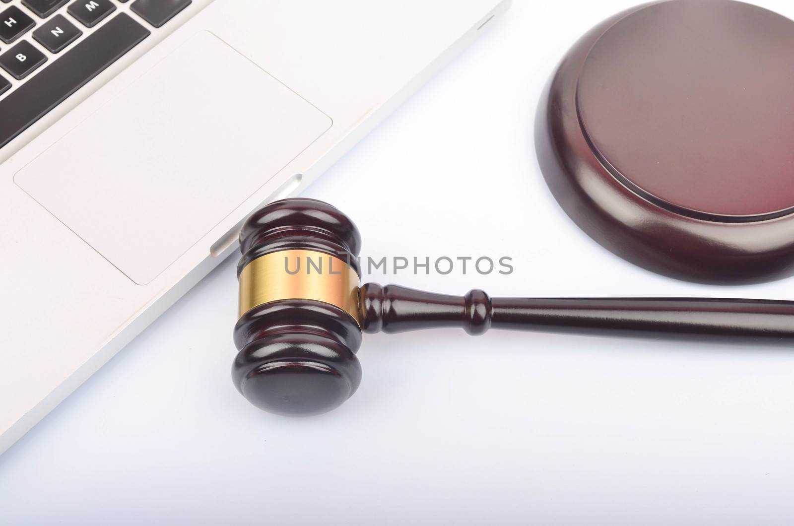 Cyber crime concept. Judge hammer or gavel with laptop on white background. Selective focus.