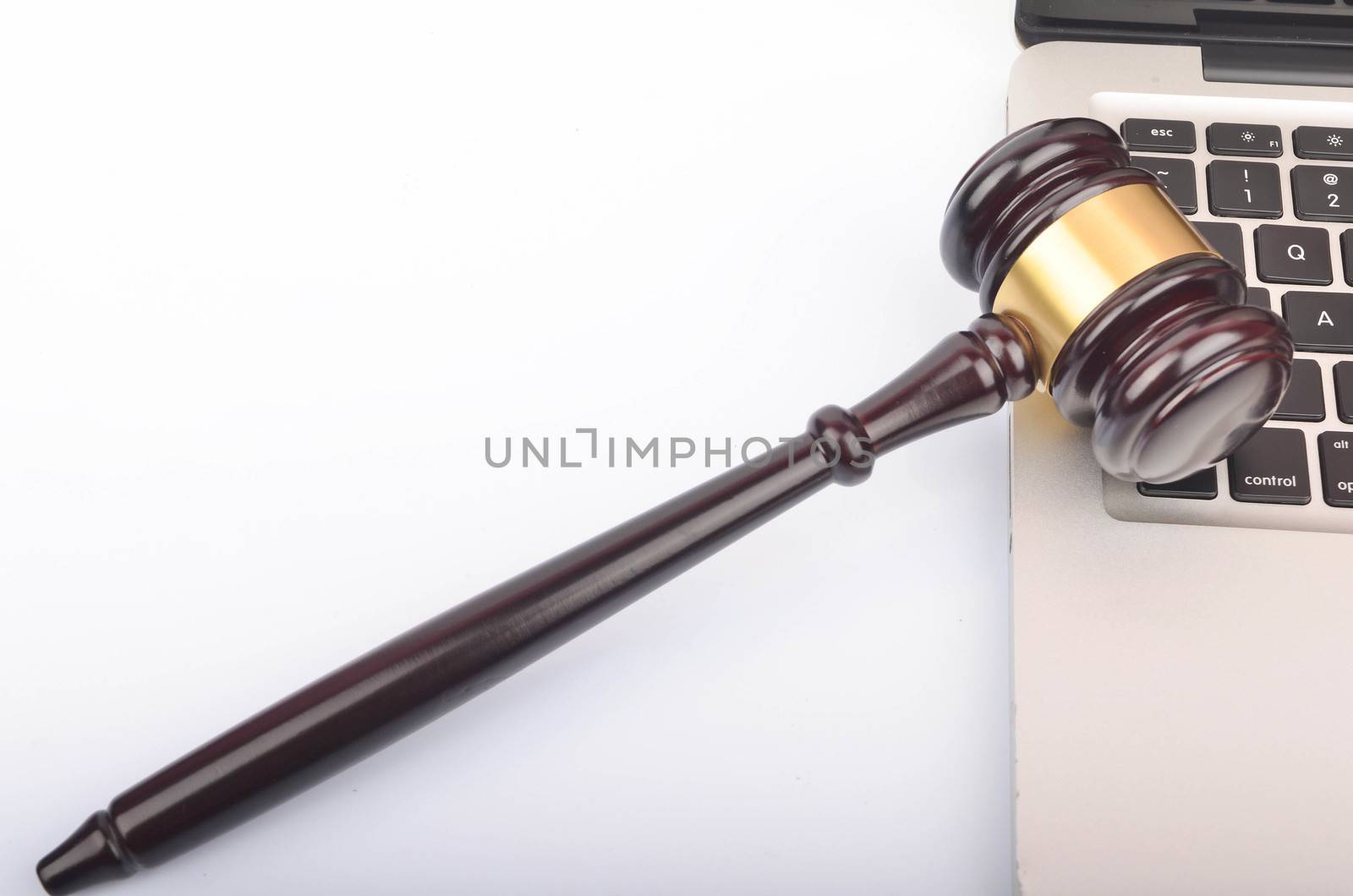 Cyber crime concept. Judge hammer or gavel with laptop on white background. Selective focus.