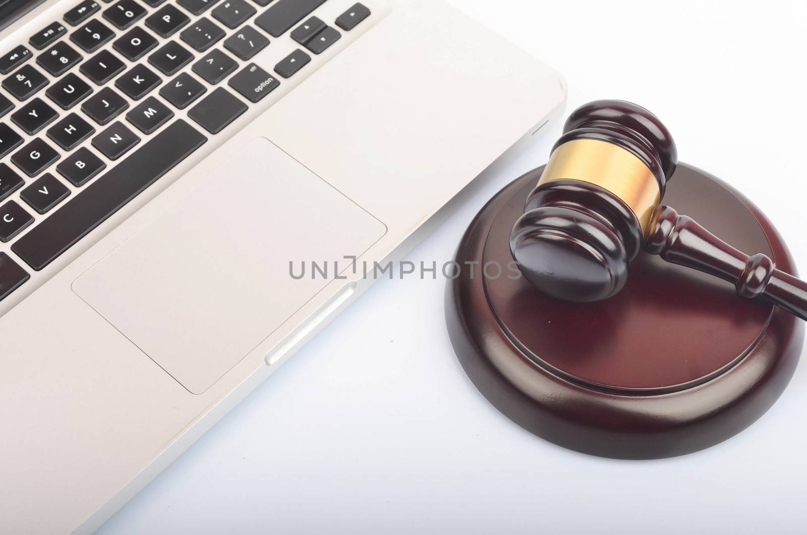 Cyber crime concept. Judge hammer or gavel with laptop on white background. Selective focus.