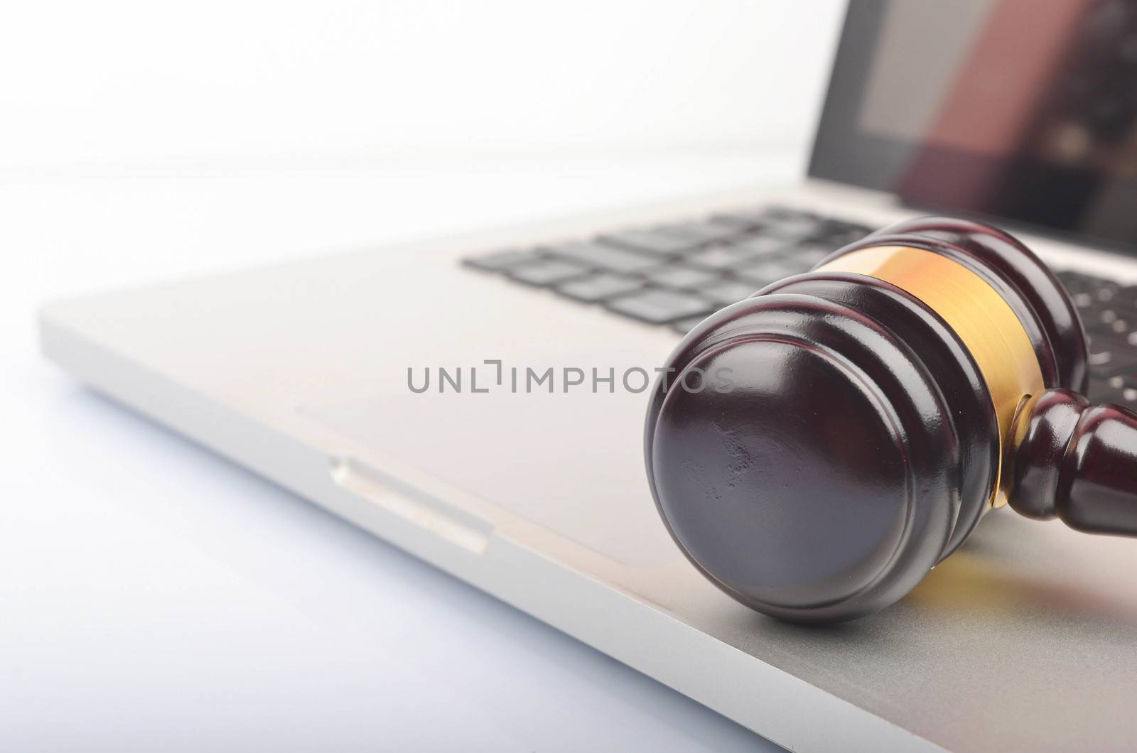 Cyber crime concept. Judge hammer or gavel with laptop on white background. Selective focus.