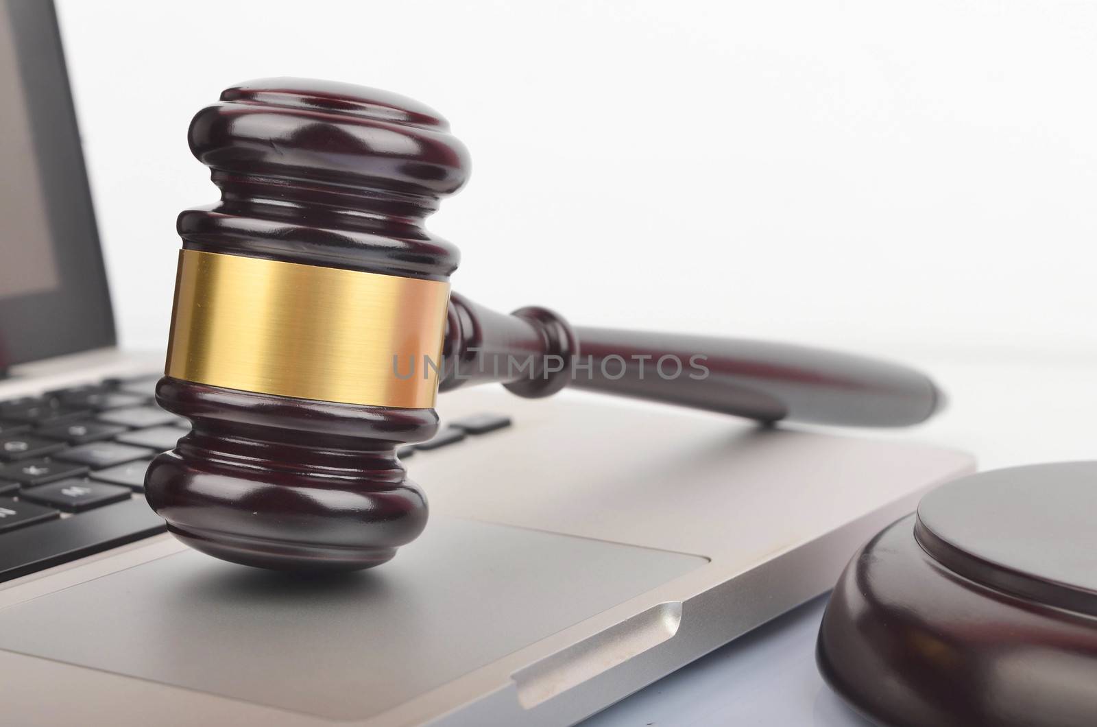 Cyber crime concept. Judge hammer or gavel with laptop on white background. Selective focus.