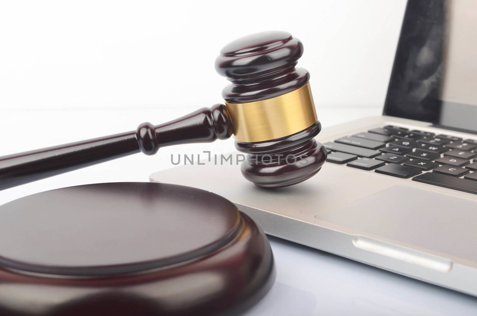 Cyber crime concept. Judge hammer or gavel with laptop on white background. Selective focus.