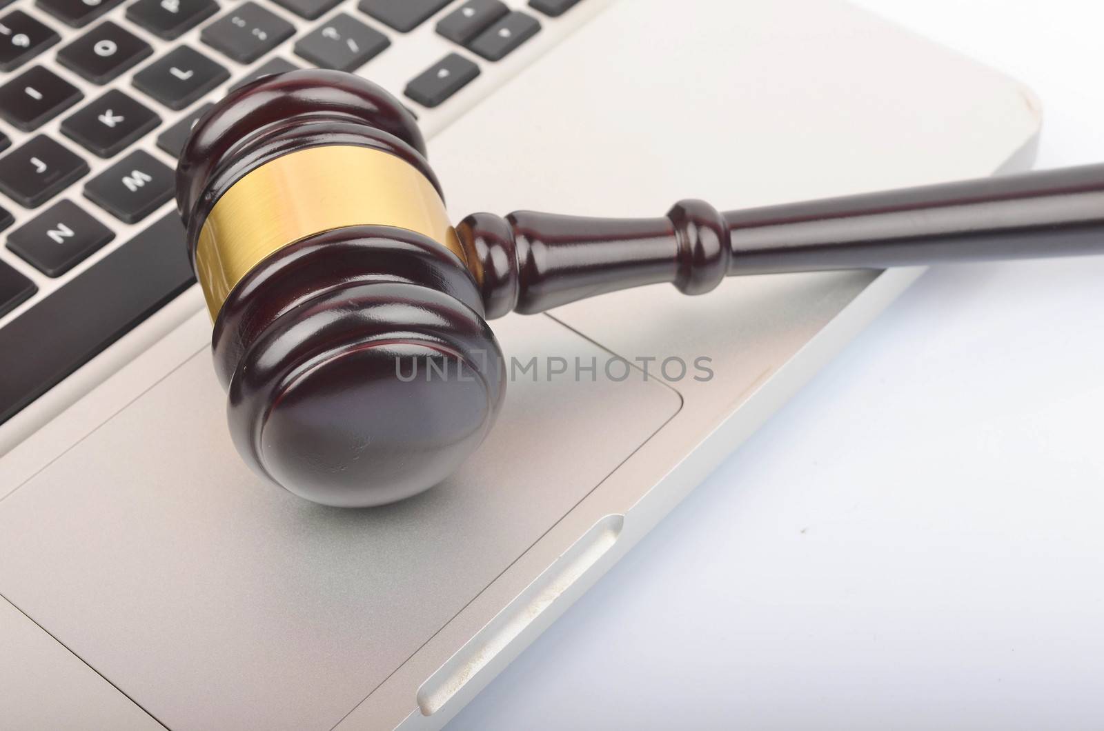 Cyber crime concept. Judge hammer or gavel with laptop on white background. Selective focus.