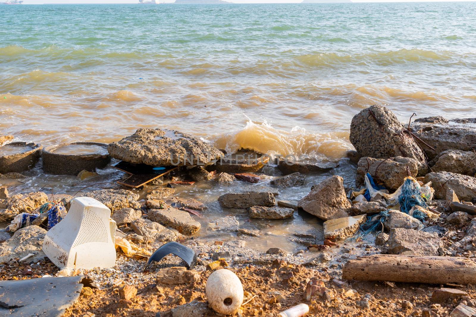 Electronic waste and foam become garbage on the beaches and birty sea water near the pier strong wind wave is a problem and pollution in Chonburi, Thailand