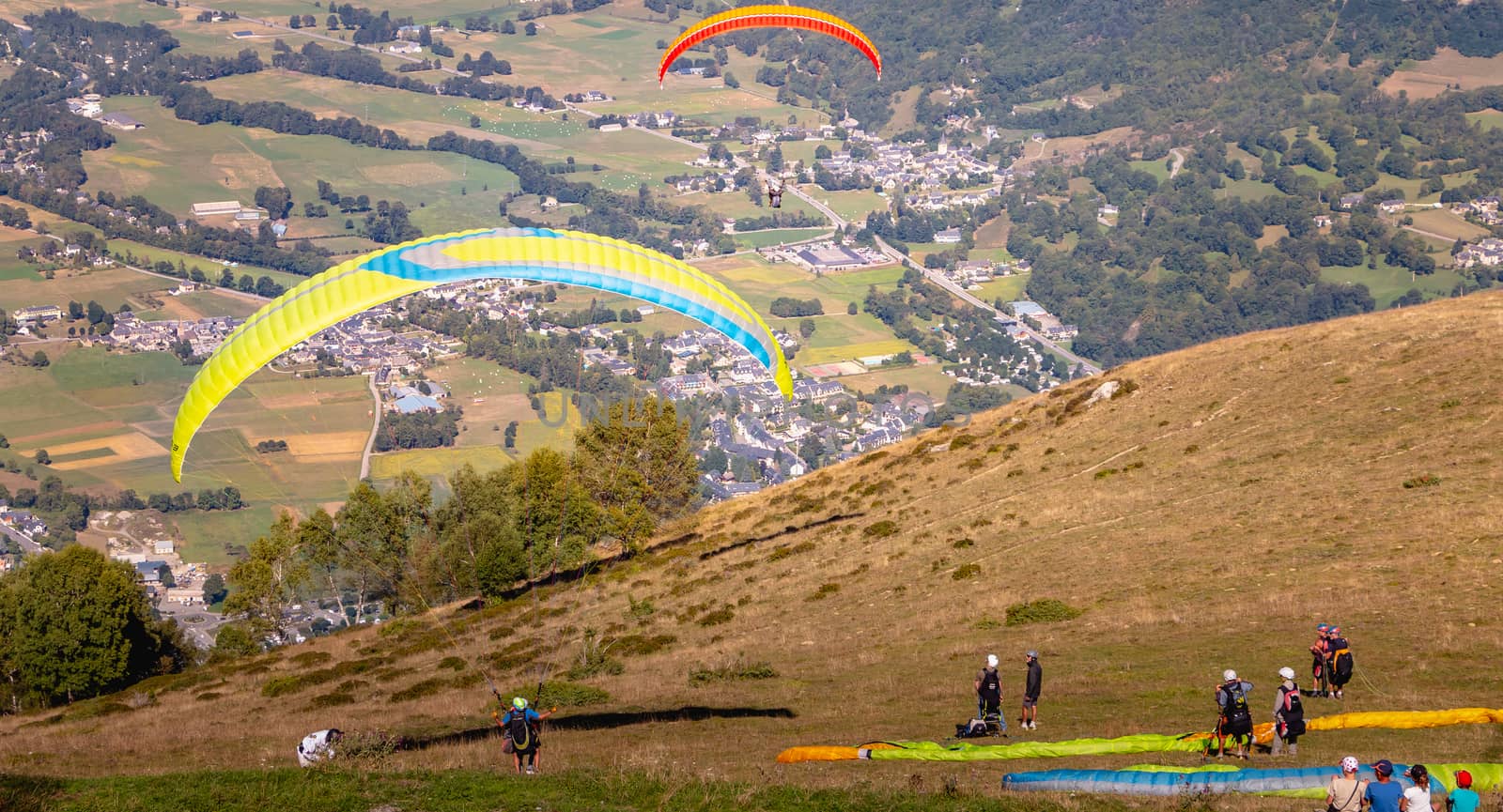 Saint Lary Soulan, France - August 20, 2018: takeoff of a paraglider from the top of the mountain, at 1700 meters altitude to fly over the valley on a summer day