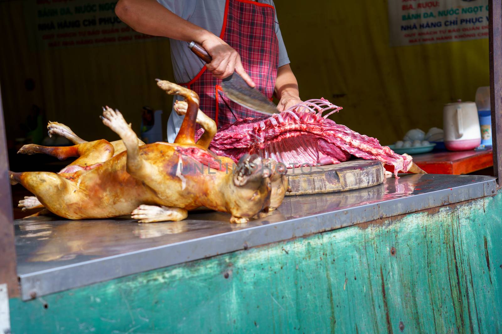 Man Dissected, pay Dog meat Dead body selling a grilled for barbecue Street food of Vietnam. Food is difficult.