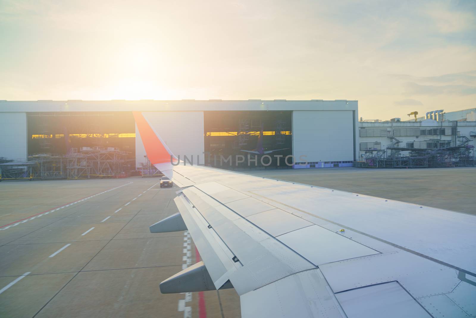 Private aviation view from inside window Airplane airliner aircraft The plane is parking bay on Terminal runway while waiting Compartment and Hangar background Sunlight and flare in BANGKOK THAILAND