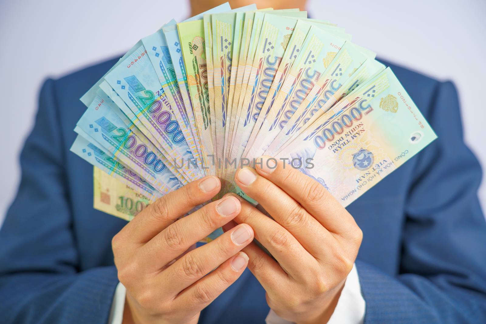 Money in Vietnam hold on hand business man wearing a blue suit (Socialist Republic Of Vietnam), Dong, VND, Pay, exchange money vietnamese on white background.