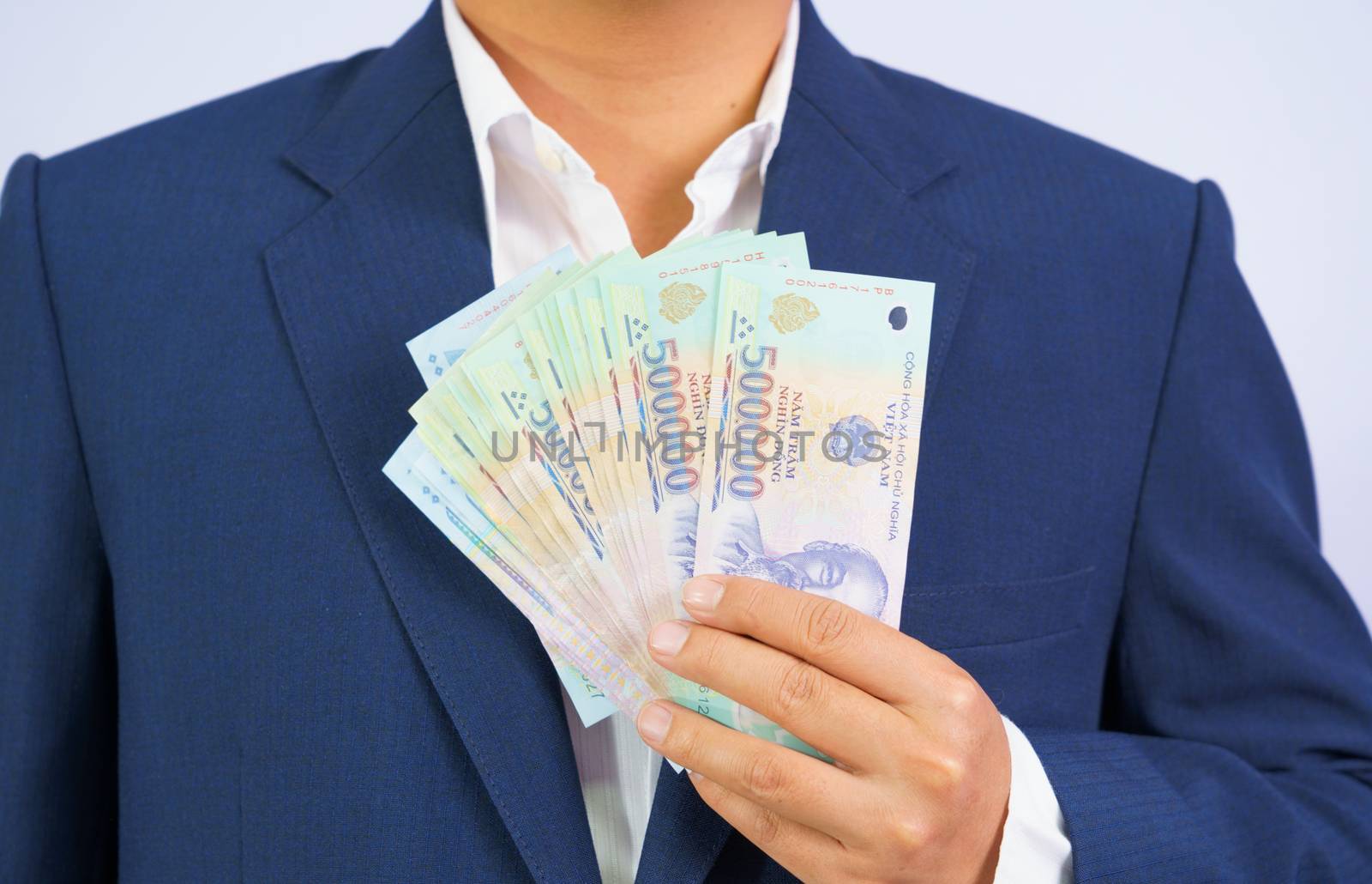 Money in Vietnam hold on hand business man wearing a blue suit (Socialist Republic Of Vietnam), Dong, VND, Pay, exchange money vietnamese on white background.